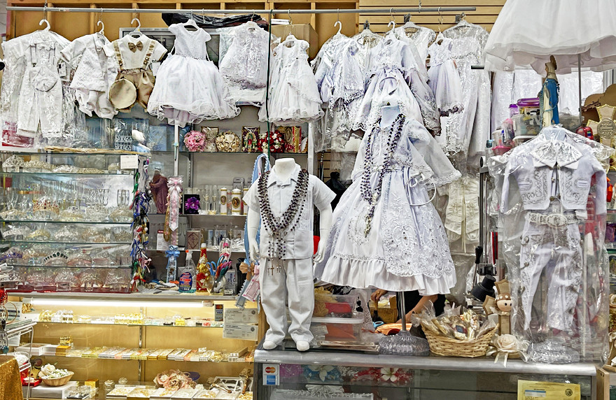 Selection of christening dresses on display at Plaza Mexico in Lynwood, California, reflecting cultural traditions and family celebrations