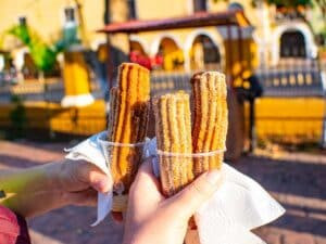 Golden brown Churros served with a side of chocolate sauce