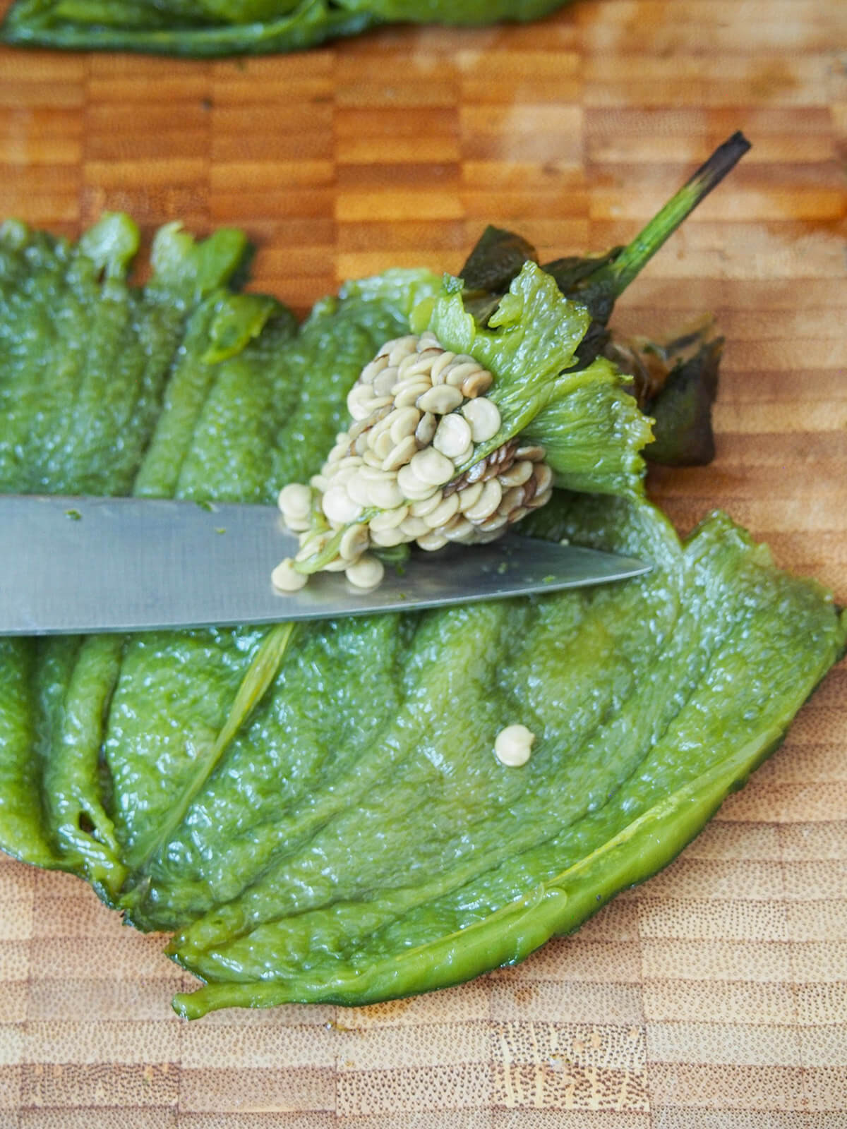 Removing seeds from a roasted poblano pepper, highlighting the meticulous preparation involved in creating the perfect Espagueti Verde.
