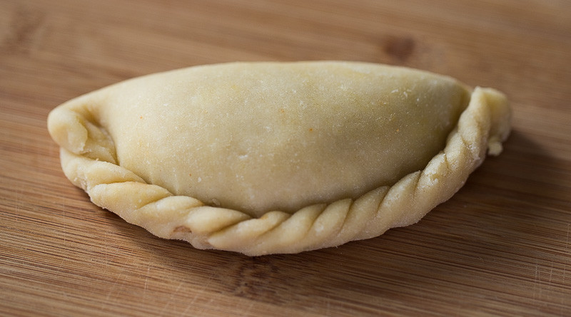 Stylized display of Mexican empanada with crimped edges