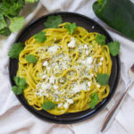 A plate of Espagueti Verde, Mexican green spaghetti, showcasing the vibrant green sauce and the comforting appeal of the dish.