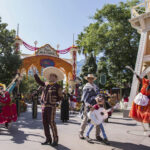 People in costumes dancing with characters inspired by Disney and Pixar