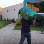 Man moving belongings into a house