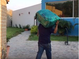 Man moving belongings into a house