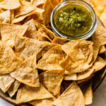 Homemade gluten-free tortilla chips cooling on a baking sheet