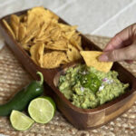 A scoop of guacamole with a chip.