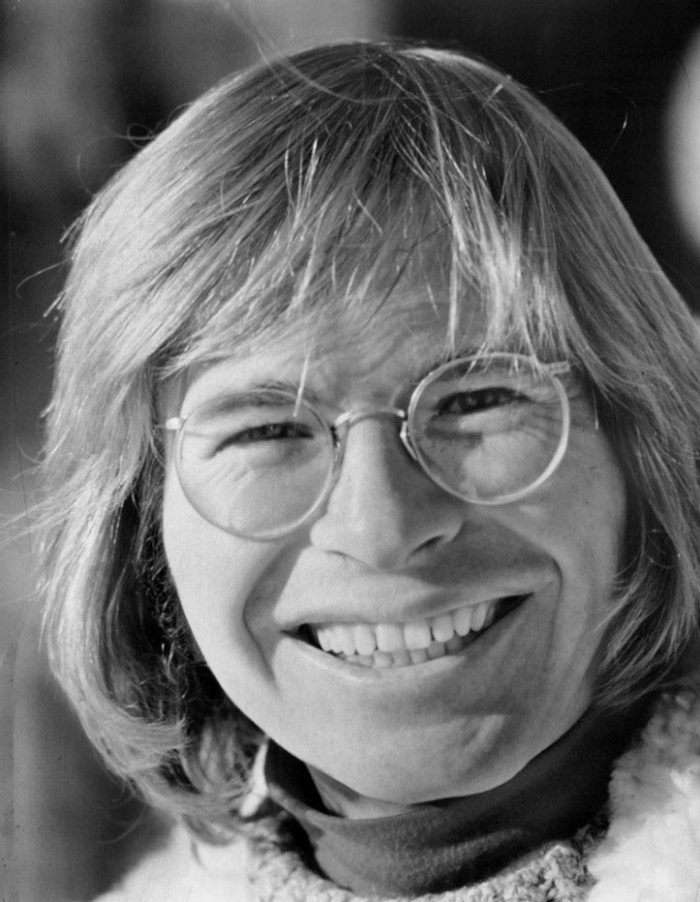 John Denver performing with a guitar