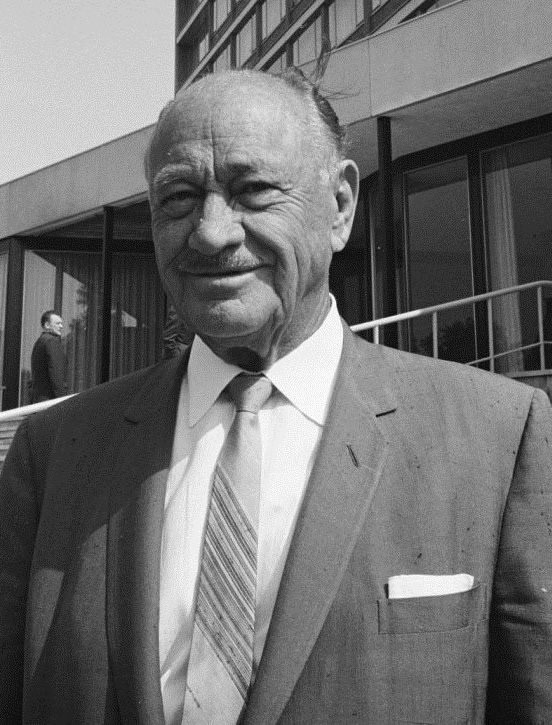 Conrad Hilton standing in front of a hotel
