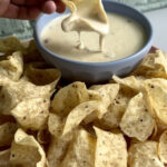 Bowl of white queso dip with tortilla chips, showcasing the creamy texture and inviting appeal.