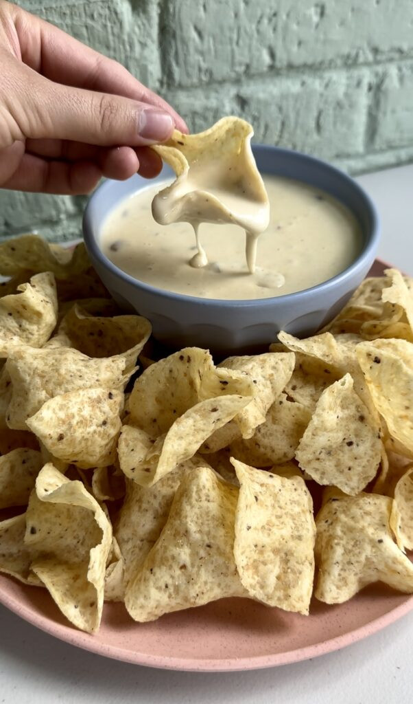 Bowl of white queso dip with tortilla chips, showcasing the creamy texture and inviting appeal.