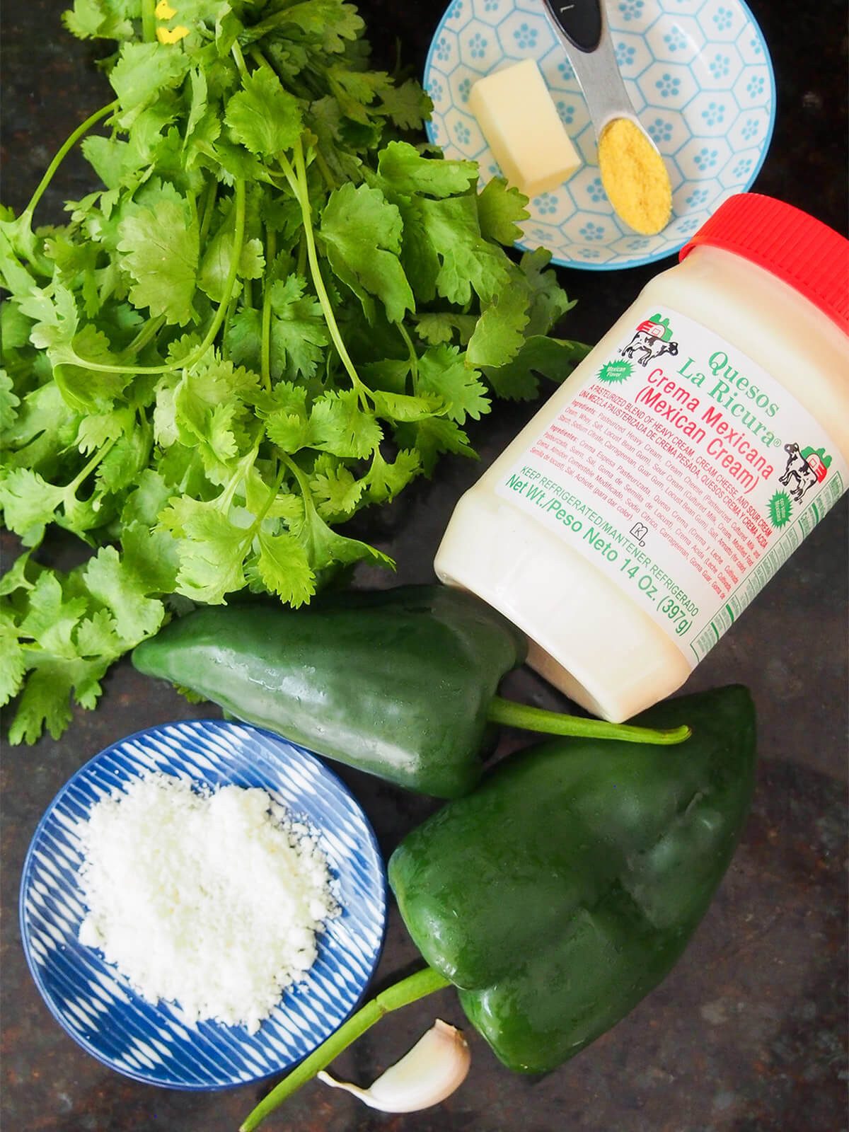 Ingredients for Espagueti Verde, including cilantro, poblano peppers, Mexican crema, and cheese, showcasing the freshness and authenticity of the dish.
