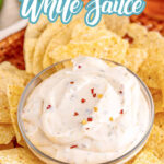 Overhead shot of Virginia white sauce in a small glass bowl surrounded by yellow corn tortilla chips