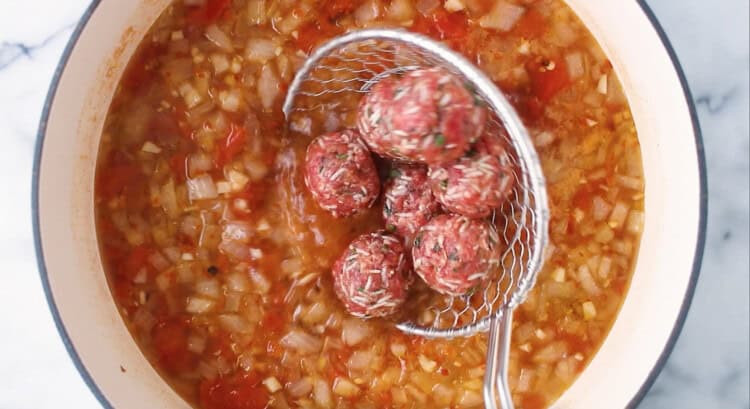 Wire ladle above pot of Albondigas