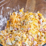 A baking dish with cornmeal, flour, cheese, green onions, green bell pepper, and canned green chili peppers