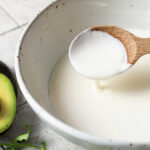 Bowl of homemade Mexican crema with a spoon