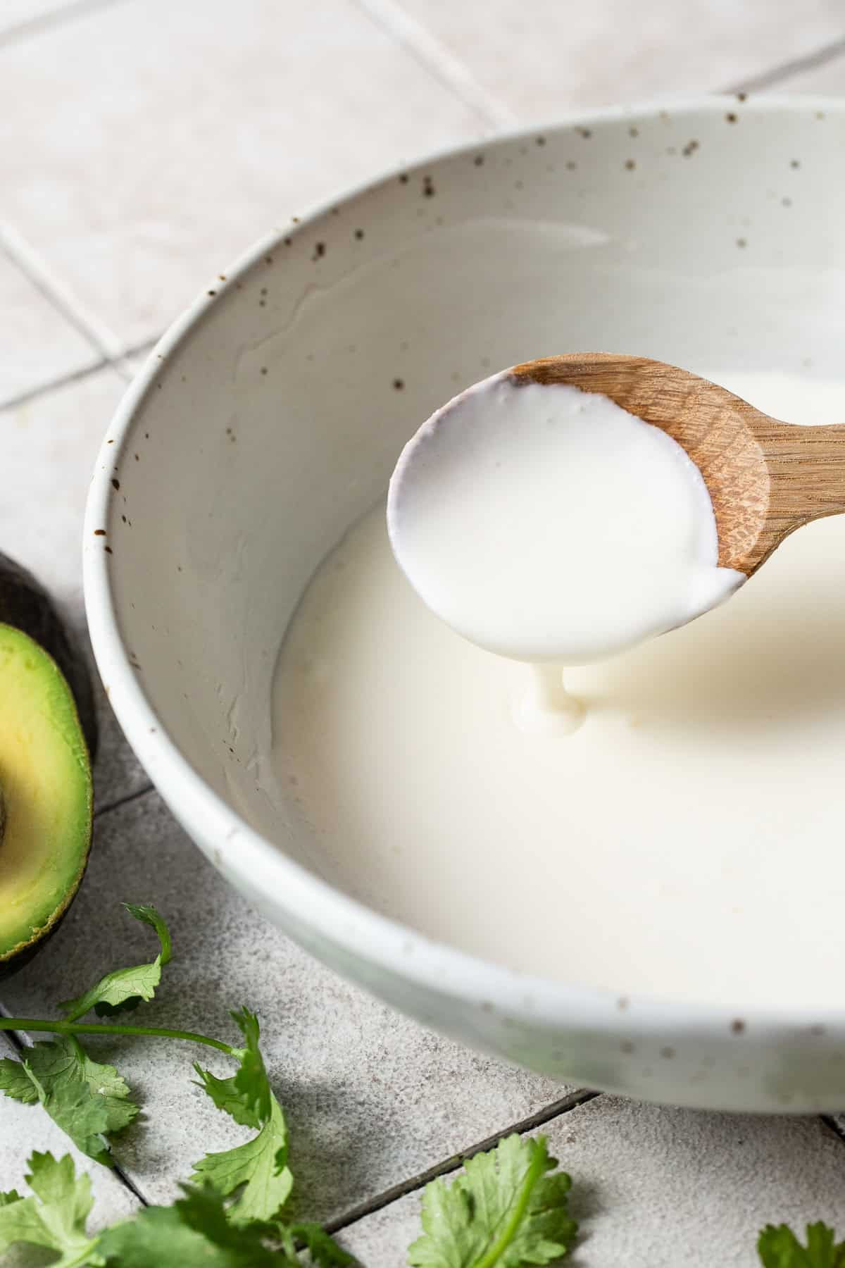 Bowl of homemade Mexican crema with a spoon