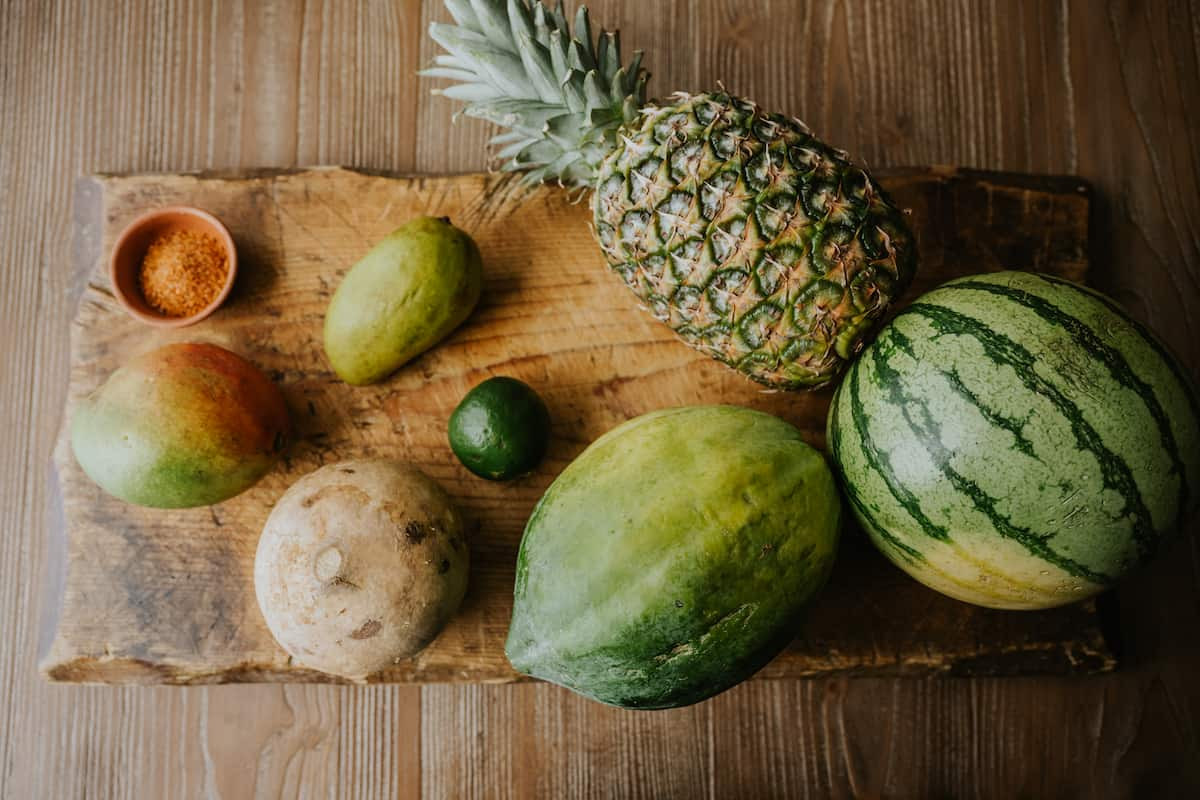 mango, jicama, papaya, pineapple, watermelon on a wooden board.