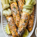 Elotes Ingredients, including corn, mayonnaise, cotija cheese, chili powder, and lime