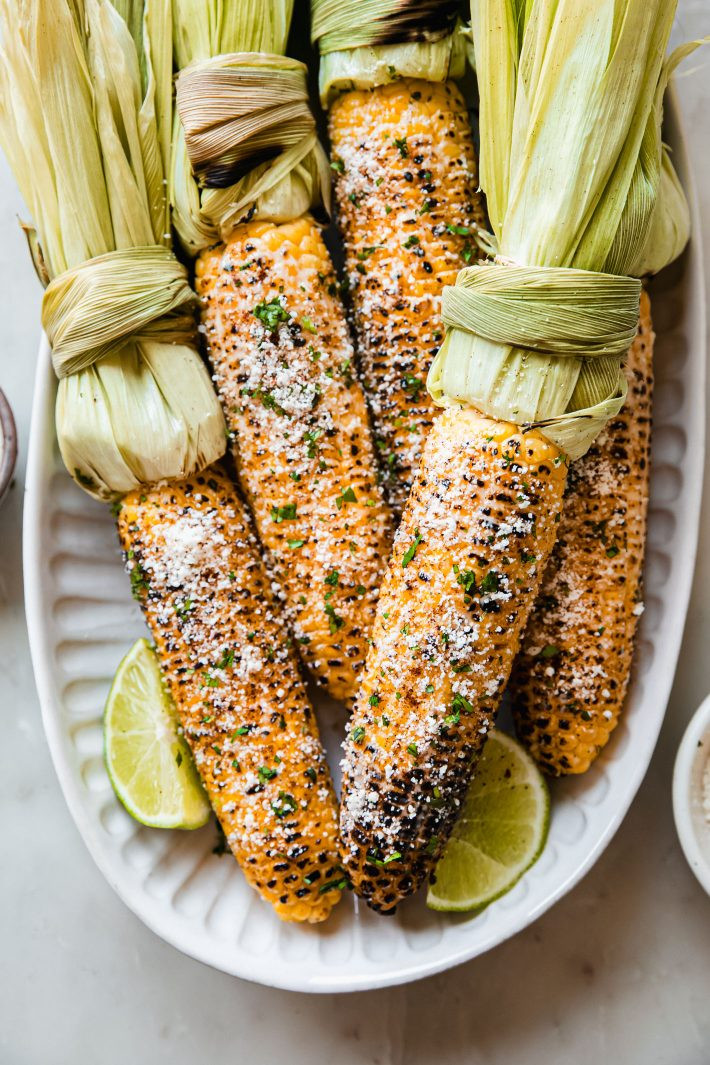 Elotes Ingredients, including corn, mayonnaise, cotija cheese, chili powder, and lime