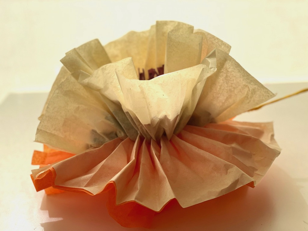 Fluffing the tissue paper layers to create a flower