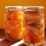 Two glass jars filled with spicy Mexican pickled carrots, showcasing their vibrant color and inviting texture
