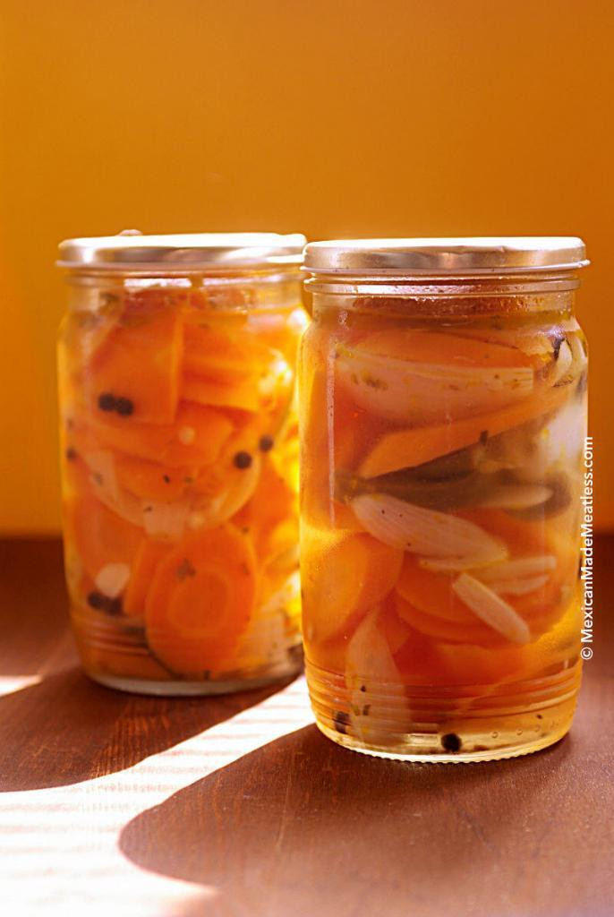 Two glass jars filled with spicy Mexican pickled carrots, showcasing their vibrant color and inviting texture