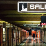 A platform of the Mexico City metro with an orange train waiting to depart on the track