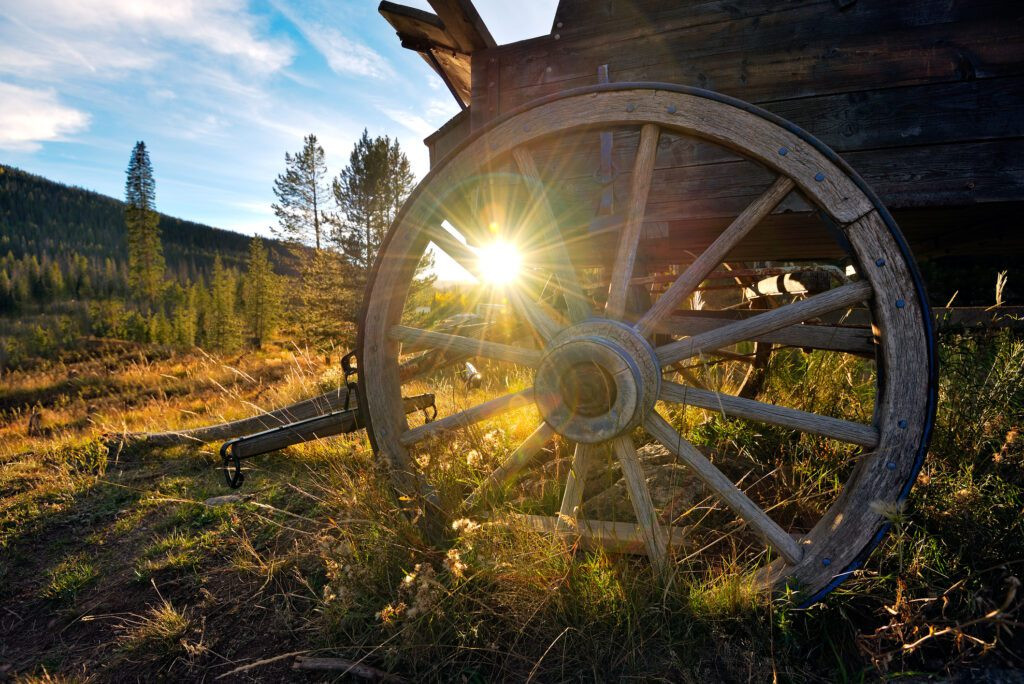 Old wagon wheel and sunset