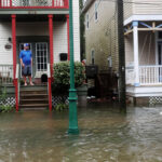 John Terrezza looks out at a flooded street in front of his home as Hurricane Sally passes through the area, in Pensacola, Fla.
