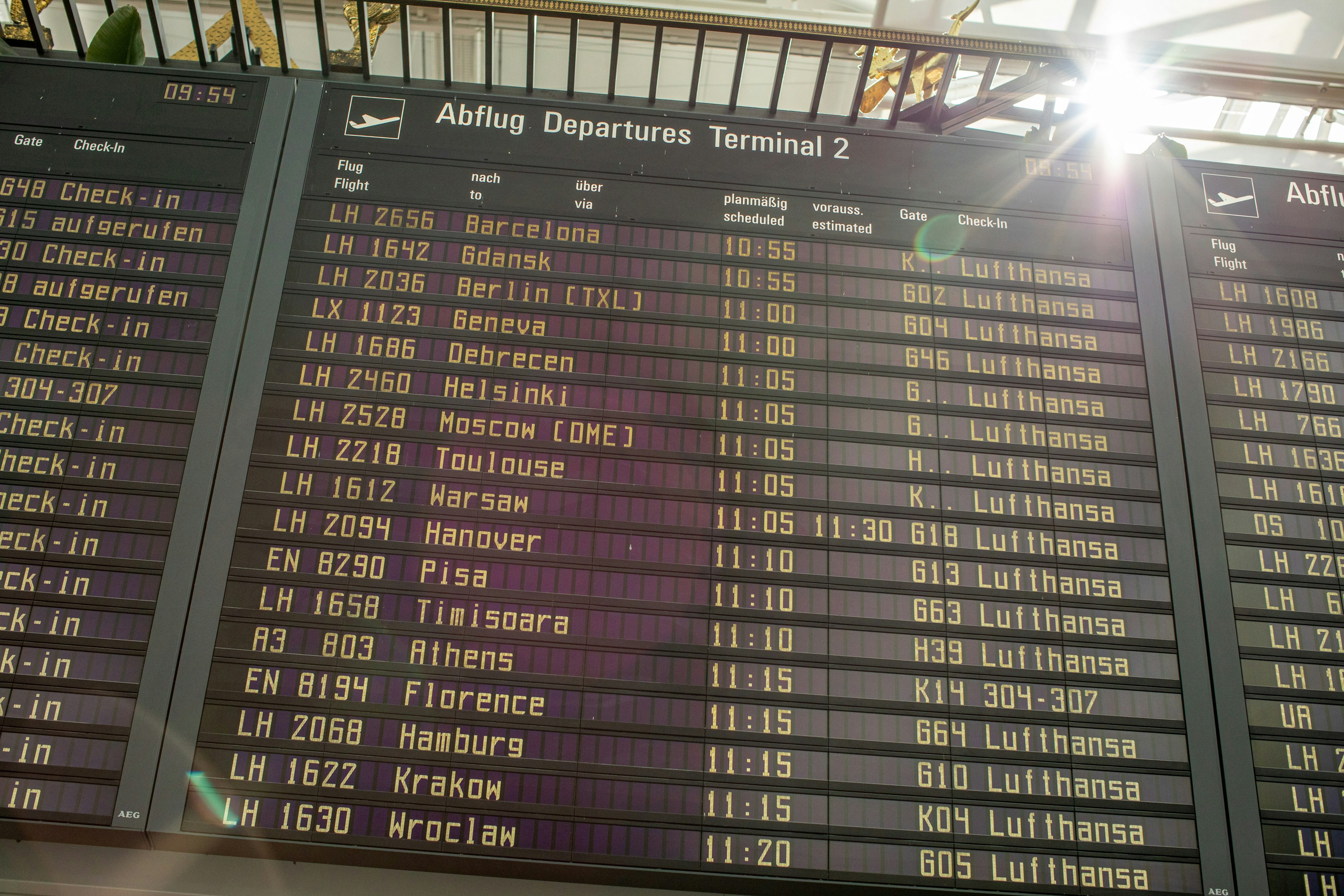 Departure board at Terminal 2 showing Lufthansa flights to European cities with scheduled times between 10:55-11:20.