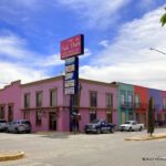 The vibrant exterior of The Pink Store in Palomas, Mexico, beckons visitors to explore its unique blend of Mexican arts, crafts, and souvenirs