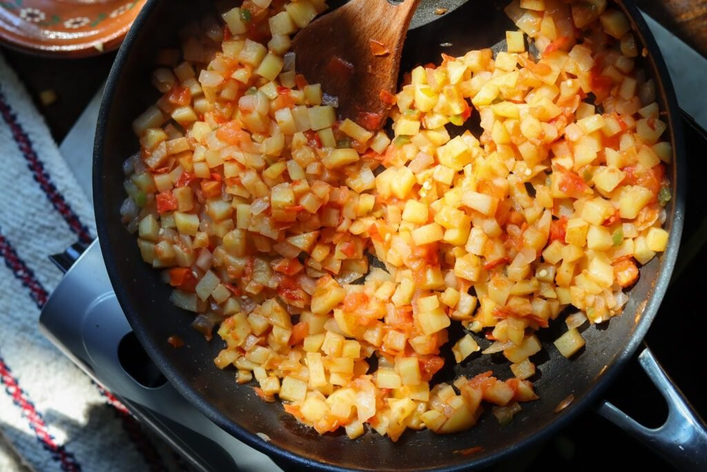Papas a la mexicana in a pan on a stove.