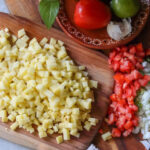 Ingredients for papas a la mexicana on a wooden board.