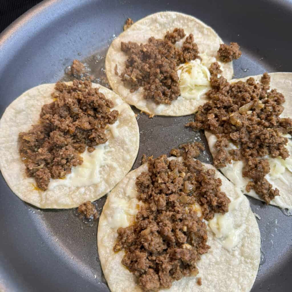 Assembling authentic Mexican tacos with various toppings