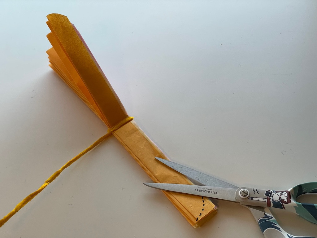 Shaping petals by cutting the ends of folded tissue paper