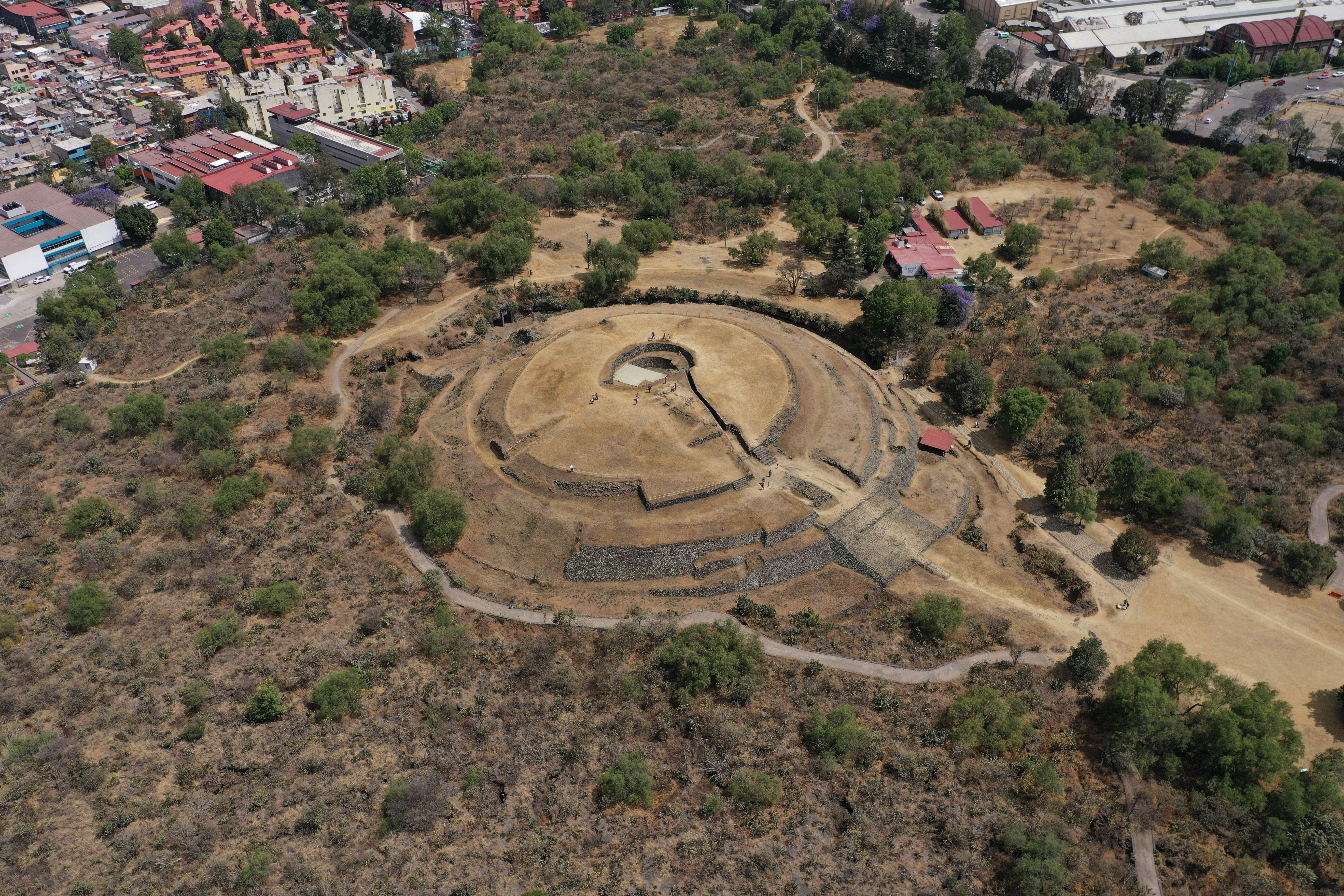 Aerial view of Cuicuilco Pyramid amidst Mexico City's urban landscape