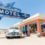 A tourist in a classic car stops at a motel at Tucumcari on Route 66 in New Mexico.