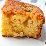 A close up of a slice of Mexican cornbread with green chiles.