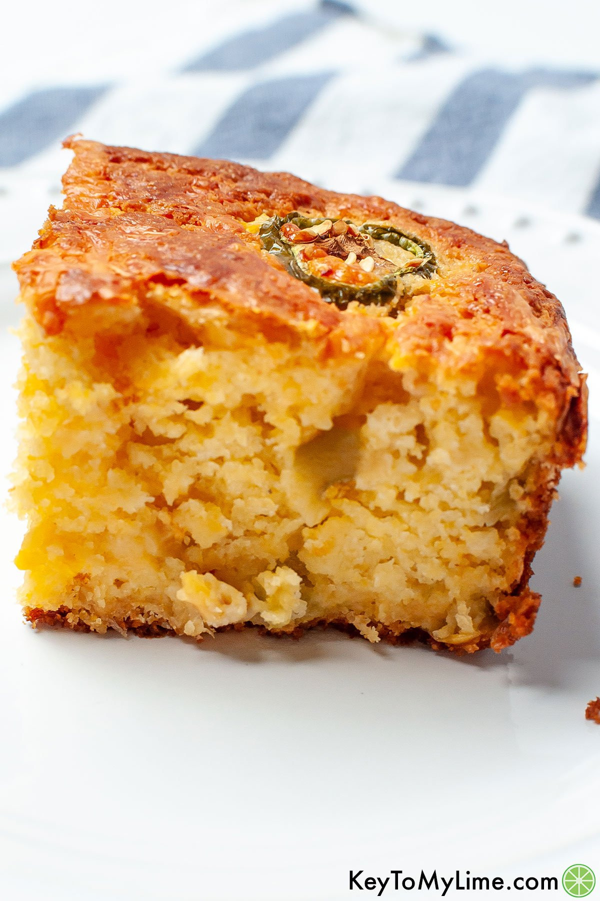 A close up of a slice of Mexican cornbread with green chiles.