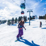 Woman snowboarding down slope