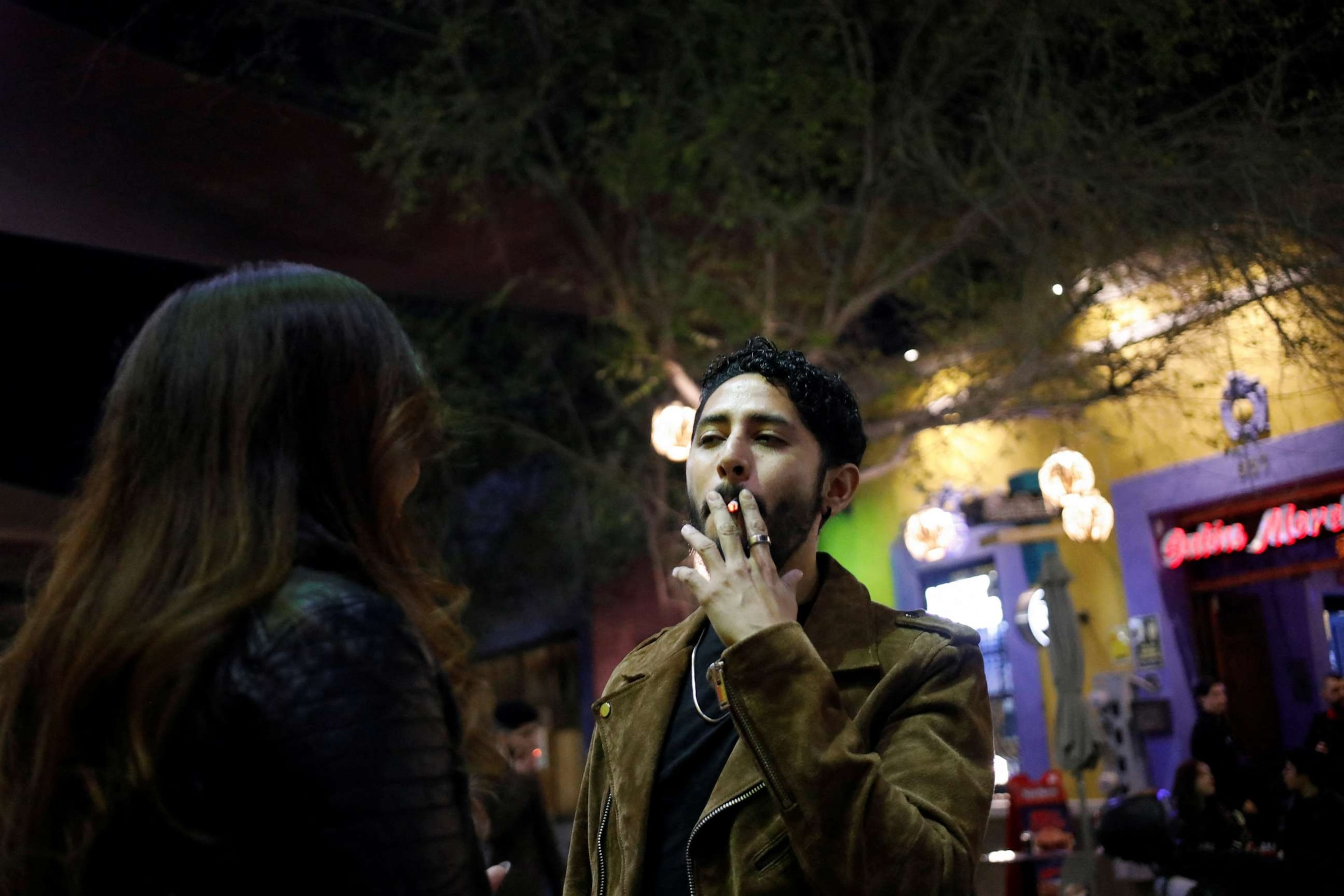 A man smokes a cigarette outside a bar in Monterrey, Mexico