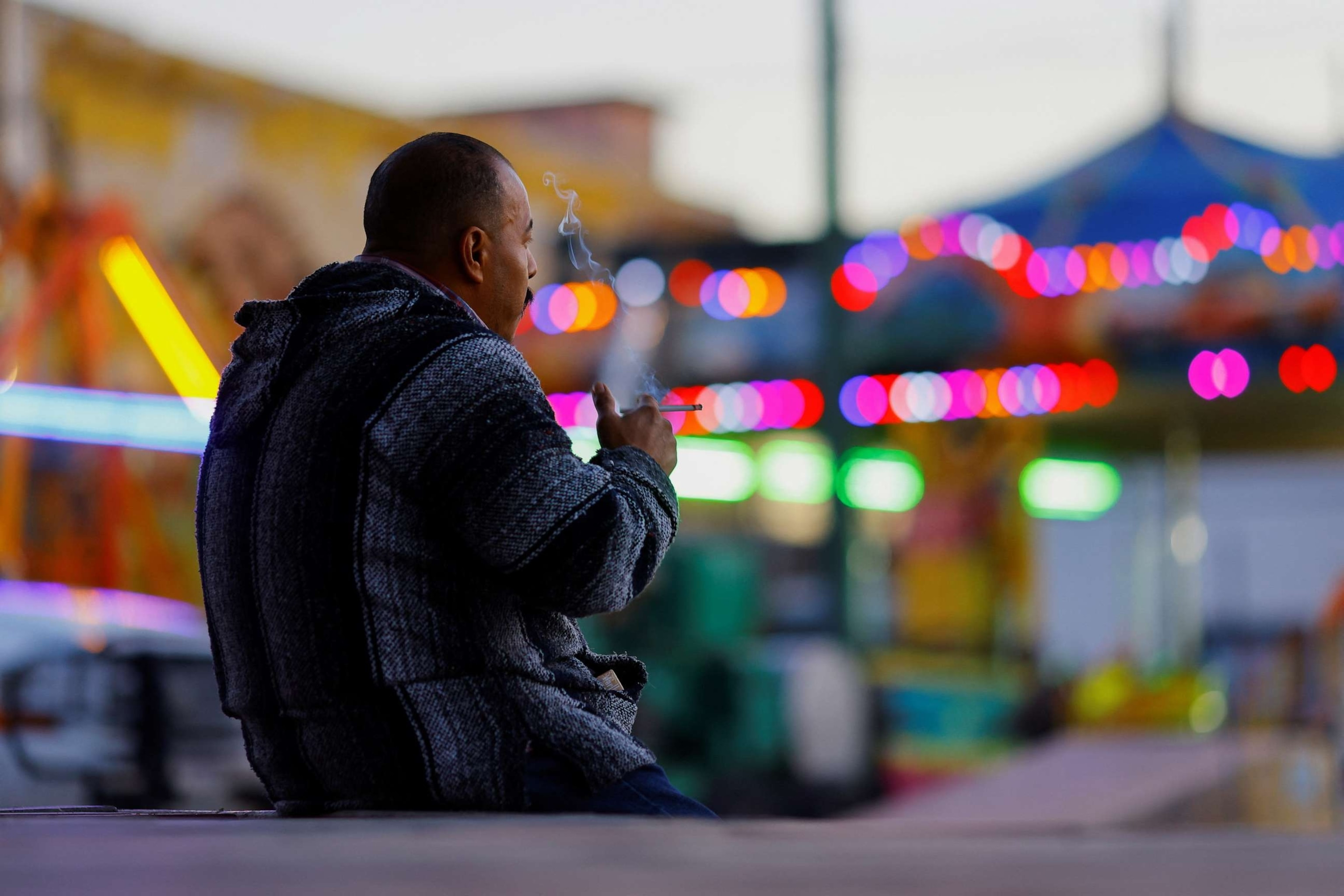 A man smokes in a public plaza in Ciudad Juarez, Mexico
