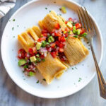 A colorful array of Mexican tamales, each uniquely wrapped and filled, showcasing the diversity of this traditional dish.