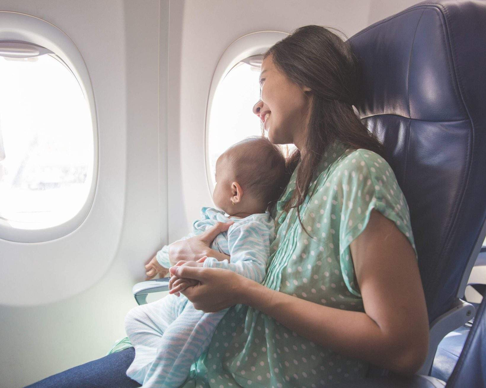 Mother and baby on a plane representing family air travel