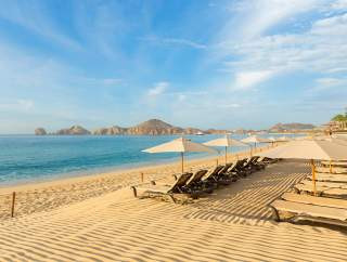 Chairs and umbrellas on Medano Beach, illustrating a relaxing beach day in Cabo San Lucas
