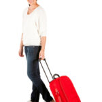 Woman in airport with luggage looking happy