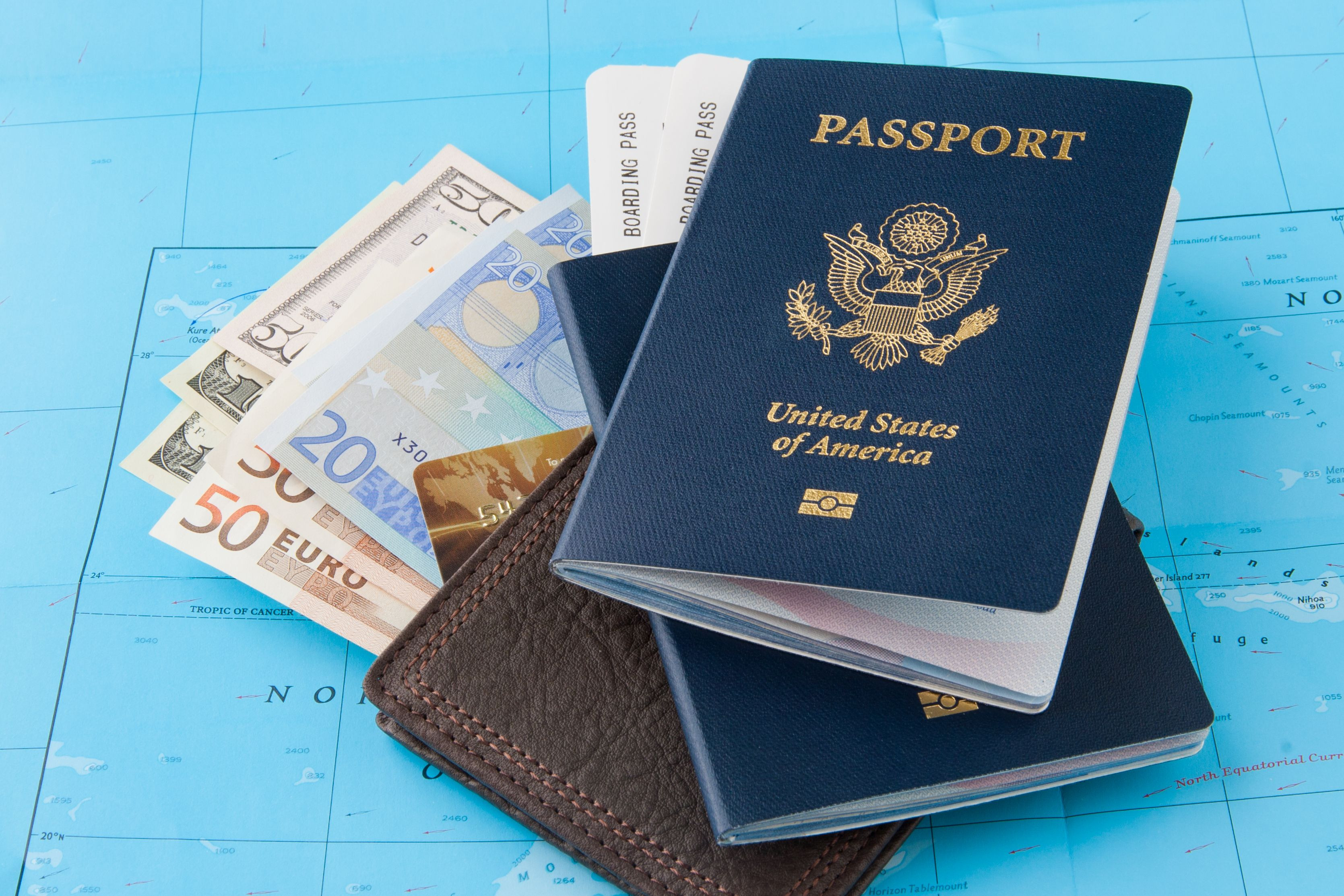 Essentials for a 7-day cruise to Mexico including a US passport, boarding pass, wallet, and mixed currency displayed on a map.