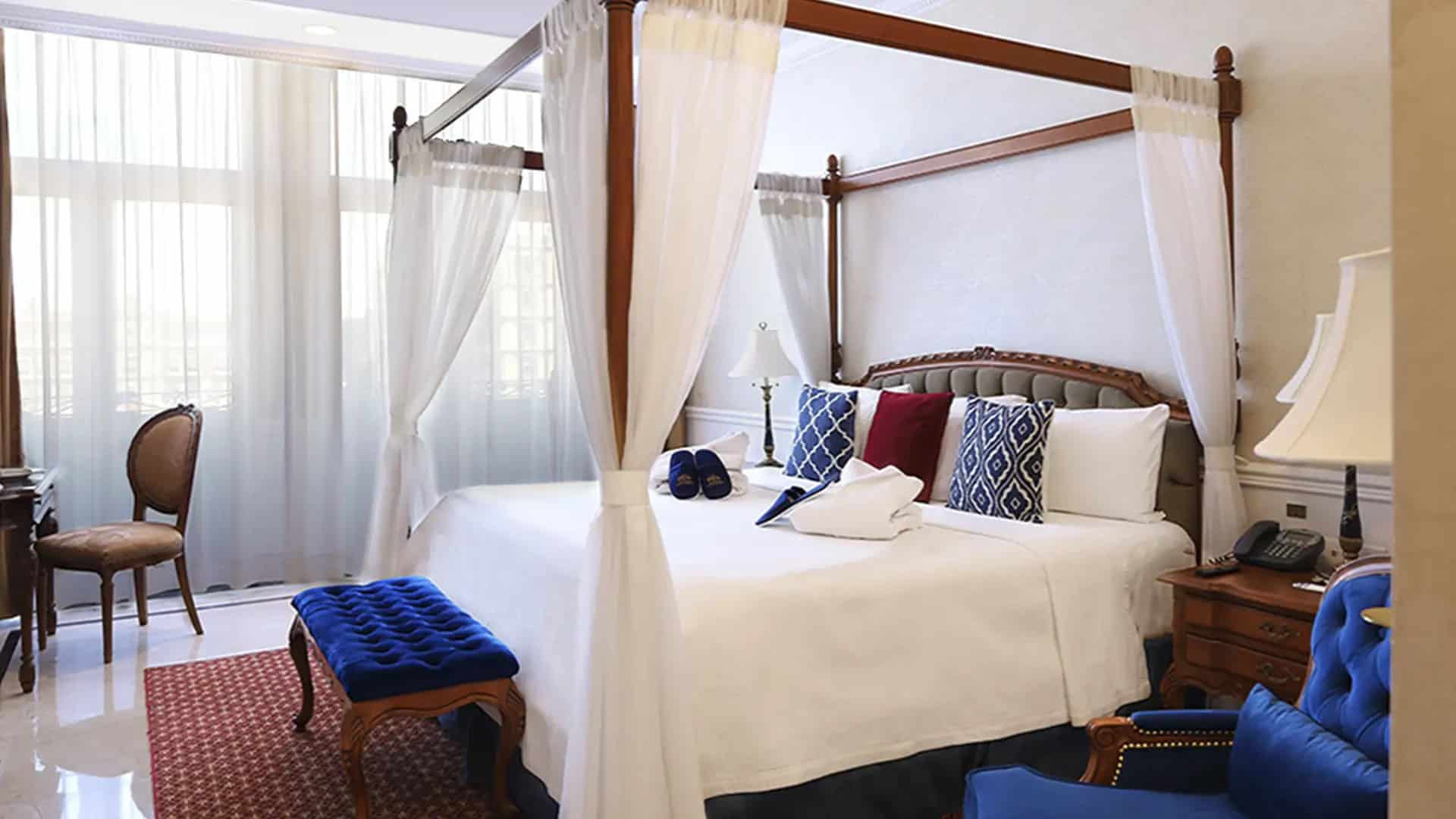 Luxury hotel bed at Gran Ciudad with views of the Zocalo, highlighting the grandeur of Centro Histórico