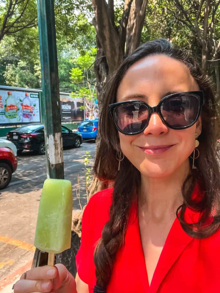 woman in red top with green popsicle for where to stay in mexico city